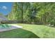 Sprawling backyard with lush lawn, a concrete patio, green Adirondack chairs, and mature trees at 599 Annalinde Ln, Rock Hill, SC 29732