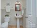 Charming half bathroom featuring a pedestal sink, wainscoting, and stylish fixtures at 599 Annalinde Ln, Rock Hill, SC 29732