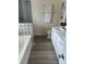 Bathroom featuring tub and shower with mosaic tile surround, double sink vanity, and wood look floors at 599 Annalinde Ln, Rock Hill, SC 29732
