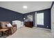 A cozy bedroom features a brown recliner, dark blue walls, a crib, and neutral carpet flooring at 599 Annalinde Ln, Rock Hill, SC 29732