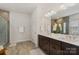 Modern bathroom boasts double sinks, decorative mirror, and glass-enclosed shower at 6114 Alsace Ln, Indian Land, SC 29707