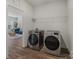 Convenient laundry room showcasing modern, front-load washer and dryer on wood-look flooring at 6114 Alsace Ln, Indian Land, SC 29707
