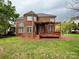 View of the red brick home's backyard featuring a wood deck with a pergola at 6316 Glengarrie Ln, Huntersville, NC 28078