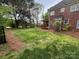 Expansive green backyard with a small deck off the brick house and some scattered trees at 6316 Glengarrie Ln, Huntersville, NC 28078