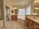 Bright bathroom featuring a soaking tub, double vanity sinks, and a separate toilet room at 6316 Glengarrie Ln, Huntersville, NC 28078