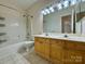 Bathroom with double sinks, bathtub, shower and toilet with wood cabinets at 6316 Glengarrie Ln, Huntersville, NC 28078