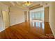 Spacious bedroom with a tray ceiling, hardwood floors, and a large window that provides natural light at 6316 Glengarrie Ln, Huntersville, NC 28078