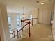 A staircase and railing lead to the upper hall featuring an elegant chandelier at 6316 Glengarrie Ln, Huntersville, NC 28078