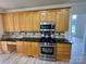 A kitchen with natural wood cabinets, stainless steel appliances, and black countertops at 6316 Glengarrie Ln, Huntersville, NC 28078