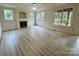 Bright living room with a fireplace, three large windows, and neutral-toned walls at 6316 Glengarrie Ln, Huntersville, NC 28078