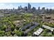 Aerial view of a neighborhood with lush trees and the city skyline in the background at 656 Garden District Dr, Charlotte, NC 28202