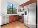 Modern kitchen with stainless steel appliances, wood cabinets, and a view of the outdoors at 656 Garden District Dr, Charlotte, NC 28202