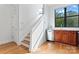 Stairway in the home leads to a kitchenette with stainless steel appliances and wooden cabinets at 656 Garden District Dr, Charlotte, NC 28202