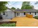 A full view of the back deck with a painted brick exterior and view of the backyard and landscaping at 6701 Highbrook Dr, Charlotte, NC 28212