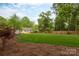 Wide view of the lush backyard with a large lawn, mature trees, and beautiful landscaping at 6701 Highbrook Dr, Charlotte, NC 28212