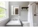 Bright bathroom featuring marble countertop, modern fixtures, and a tiled shower with curtain at 6701 Highbrook Dr, Charlotte, NC 28212