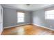 Bedroom with hardwood floors, two windows, neutral paint and white trim at 6701 Highbrook Dr, Charlotte, NC 28212