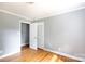 Bedroom with hardwood floors and neutral paint, showcasing closet and doorway at 6701 Highbrook Dr, Charlotte, NC 28212