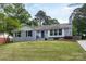 Charming gray brick home with a well-manicured front yard and a pop of color on the front door at 6701 Highbrook Dr, Charlotte, NC 28212