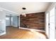 Open concept living room featuring hardwood floors, a wood accent wall, and bright natural light at 6701 Highbrook Dr, Charlotte, NC 28212