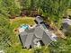 Aerial view of property showcasing the house, in-ground pool, and wooded surroundings at 7181 Windy Ridge Dr, Iron Station, NC 28080