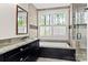 Bathroom features a luxurious tub, window and a vanity with granite countertop with ample storage at 7181 Windy Ridge Dr, Iron Station, NC 28080