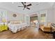 Spacious bedroom features hardwood floors, fan, French doors leading to covered outdoor seating area at 7181 Windy Ridge Dr, Iron Station, NC 28080