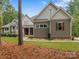 Exterior shot of a two story house with neutral colored siding and professionally landscaped yard at 7181 Windy Ridge Dr, Iron Station, NC 28080