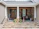Charming front porch with stone accents, columns, and a welcoming entrance at 7181 Windy Ridge Dr, Iron Station, NC 28080
