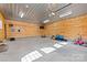 Spacious garage with wood paneled walls, concrete floor, and an abundance of lighting at 7181 Windy Ridge Dr, Iron Station, NC 28080