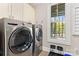 Modern laundry room featuring high-end stainless steel washer and dryer set at 7181 Windy Ridge Dr, Iron Station, NC 28080