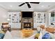 Living room with cozy fireplace, built-in shelving, ceiling fan and large comfortable sofas at 7181 Windy Ridge Dr, Iron Station, NC 28080