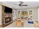 A cozy living room with stone fireplace that opens to the outdoor pool area at 7181 Windy Ridge Dr, Iron Station, NC 28080