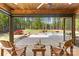 Inviting covered patio area features wood-burning fireplace, outdoor seating, and view of pool and yard at 7181 Windy Ridge Dr, Iron Station, NC 28080