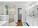 Well-lit bathroom featuring a glass-enclosed shower with green accent tiles and a double sink vanity at 7200 Monroe Rd, Charlotte, NC 28212