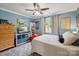 Comfortable bedroom with bright blue walls, a ceiling fan, and ample toy storage on shelving at 7200 Monroe Rd, Charlotte, NC 28212
