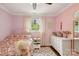 Cozy bedroom with pink walls, a chevron patterned rug, and a white nightstand with a lamp at 7200 Monroe Rd, Charlotte, NC 28212