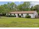 Charming single-story home featuring a well-manicured lawn, mature trees and landscape, and a classic brick exterior at 7200 Monroe Rd, Charlotte, NC 28212