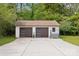 Detached two-car garage with modern doors and a seating area at 7200 Monroe Rd, Charlotte, NC 28212