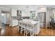Modern kitchen featuring white cabinets, stainless steel appliances, a center island, and stylish pendant lighting at 7200 Monroe Rd, Charlotte, NC 28212