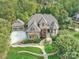 An aerial view of a stately brick home showcasing lush landscaping and a winding stone pathway at 7311 Barrington Ridge Dr, Fort Mill, SC 29707