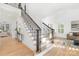Bright foyer featuring wood floors, a staircase with ornate iron railings, and natural light from large windows at 7311 Barrington Ridge Dr, Fort Mill, SC 29707