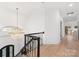 Open hallway with stairs, featuring hardwood floors and a decorative chandelier at 7311 Barrington Ridge Dr, Fort Mill, SC 29707