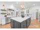 Open kitchen boasts a large island with marble countertop, stainless steel appliances, and wood floors at 7311 Barrington Ridge Dr, Fort Mill, SC 29707