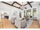 Spacious living room with exposed wood beams, an elegant chandelier, and open access to other areas of the home at 7311 Barrington Ridge Dr, Fort Mill, SC 29707