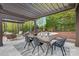 Outdoor dining area with a pergola, modern chairs, and a view of the landscaped backyard at 7311 Barrington Ridge Dr, Fort Mill, SC 29707