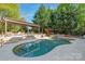 Resort-style pool area with a pergola, stone accents, and mature trees for privacy and relaxation at 7311 Barrington Ridge Dr, Fort Mill, SC 29707