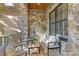Relaxing outdoor porch with stone walls, comfortable seating, and stylish decor, ideal for enjoying the outdoors at 7311 Barrington Ridge Dr, Fort Mill, SC 29707