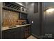 This stylish wet bar features custom cabinetry, a wine fridge, and unique tile backsplash at 7311 Barrington Ridge Dr, Fort Mill, SC 29707