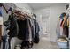 Carpeted walk-in closet with shelving and hanging racks for clothes and accessories at 8018 Green Heron Ct, Belmont, NC 28012
